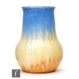 A Ruskin Pottery small vase in a streaked blue, yellow and orange crystalline glaze, height 16cm.