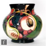 A Moorcroft Pottery vase in the Queen's Choice pattern, of footed squat ovoid form with everted rim,