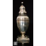 A George III hallmarked silver baluster castor to a square base with bright cut decoration below