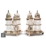 A pair of hallmarked silver and clear glass three bottle cruets each with cylindrical diamond cut