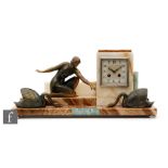 An Art Deco French coloured marble mantle clock mounted with a figure feeding two swans, eight day