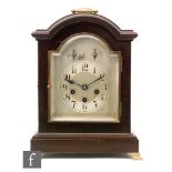 An Edwardian mahogany bracket clock with eight day chiming movement, the arched silvered dial