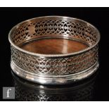 A George III hallmarked silver circular coaster with pierced gallery to a turned wooden base,