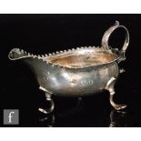 A George III hallmarked silver sauce boat of plain form with beaded borders and flying scroll