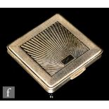 An Art Deco style hallmarked silver square compact with central sunburst decoration within engine