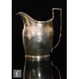 A George III hallmarked silver boat shaped cream jug with floral bright cut frieze below reeded