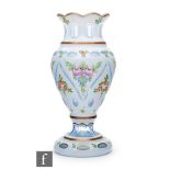 A later 20th Century Bohemian vase of footed ovoid form with a collar neck and petal edged rim cased