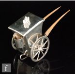 A novelty white metal tea caddy or sugar box, modelled as a rickshaw, unmarked, height 13cm and