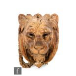 An early 19th Century carved walnut lion mask embellishment, some old loss, height 29cm.