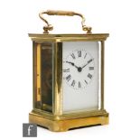 An early 20th Century brass and bevelled glass carriage clock, with white enamelled dial, movement