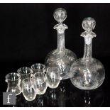 A pair of early 20th Century decanters of dimpled globe and shaft form, wrythen moulded to the