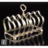 A hallmarked silver six division toast rack of plain shaped form, length 11cm, Birmingham 1931,