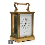 A 20th Century brass and bevelled glass cased carriage clock, the white enamelled dial with Roman