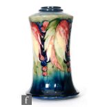 William Moorcroft - A Leaf and Berry pattern lamp vase of waisted form, rising from a splayed