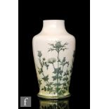 Ruskin Pottery - A vase of footed baluster form decorated in the round with hand painted thistle and