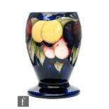 William Moorcroft - A vase of footed ovoid form decorated in the Wisteria pattern decorated with