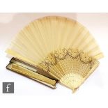 A 19th Century carved and pierced ivory fan, the centre with a monogram within exotic birds and