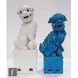 Two 20th Century Chinese glazed shishi figures, each raised on a high plinth base in a recumbent