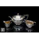 A hallmarked silver three piece bachelor's boat shaped tea set with part fluted decoration, total