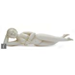 A Chinese late 19th to early 20th Century carved ivory medicine figure, carved as a recumbent nude