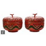 A pair of Chinese red cinnabar lacquer lidded pots, each of rounded peach form, surmounted by a