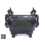 A late 19th Century Chinese cast bronze censer, the rounded rectangular form vessel raised on four
