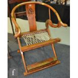 A Chinese brass mounted elm folding horseshoe shaped elbow chair, the fret-cut back splat detailed