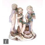 A 19th Century continental figural group of three young boys in loose robes holding floral garlands,