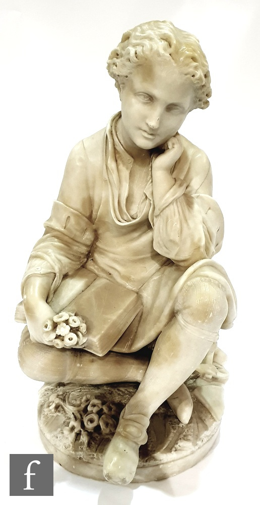 A late 19th Century Italian alabaster figure of a young boy sat crossed legged reading a book and