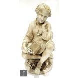 A late 19th Century Italian alabaster figure of a young boy sat crossed legged reading a book and