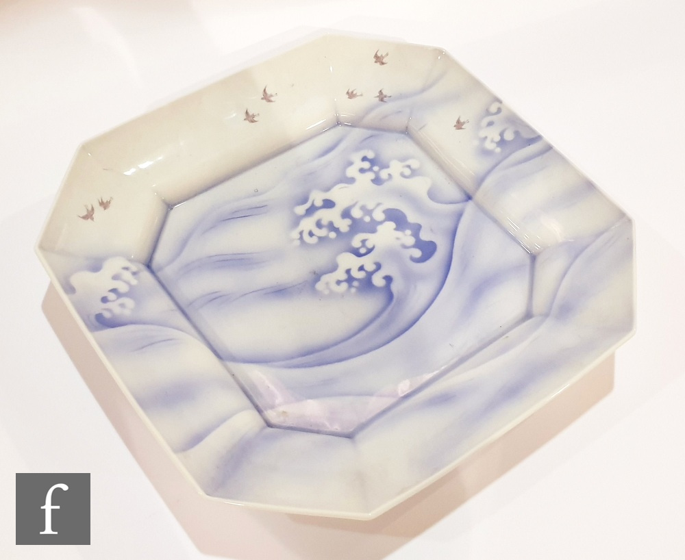 A Japanese Arita porcelain dish of canted square form, painted in blue enamels with crashing waves