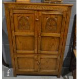 A small 17th Century style carved oak two door cupboard enclosed by a pair of carved arch doors