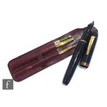 A Caran d' Ache fountain and ball point pen set in a leather holder and a large black cased