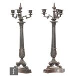 A pair of 20th Century French empire bronze candlesticks, each with triple sconces on reeded columns