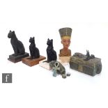 A small museum bust of Nefertiti, three facsimile Egyptian cats, and various souvenir and tourist