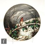An English porcelain wall charger of circular form, the central well painted with a winter scene