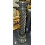 A small 20th Century green serpentine stone pedestal, the circular top above a part spiral column on