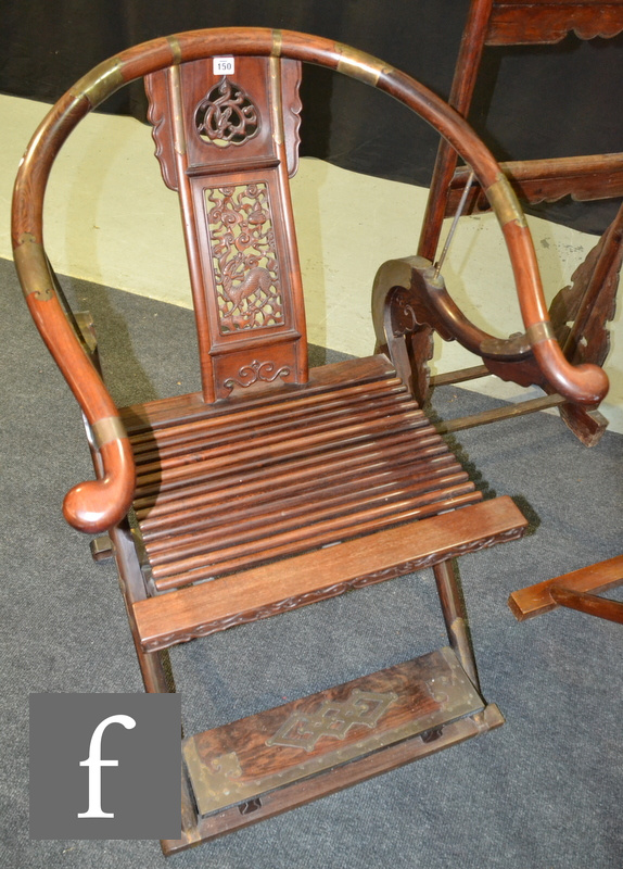 A Chinese 20th Century hardwood horseshoe-back folding chair with a carved openwork splat with