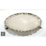 A hallmarked silver circular salver of plain form raised on three stepped pad feet, diameter 26cm,