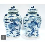 A pair of Chinese 20th Century blue and white jars and covers of baluster form, surmounted by a