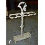 A Victorian white painted cast iron four divisioned stick stand on a tray and splayed feet base,
