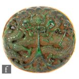 A Chinese late Qing Dynasty carved green hardstone belt buckle, the circular panel carved with