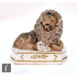A 19th Century Staffordshire figure of a lion and lamb, the recumbent lion and lamb mounted on a