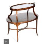 An early 20th Century mahogany two-tier etagere of oval form, with rosewood and satinwood line