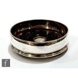 A modern hallmarked silver bottle coaster of plain form with turned wooden base, diameter 12cm,