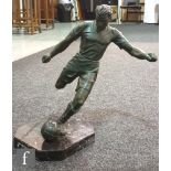 A 1950s spelter bronzed figure of a footballer kicking a stitched leather football on octagonal