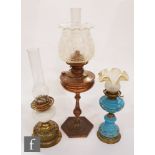 A collection of three late 19th to early 20th Century oil lamps, to include a blue opaline glass