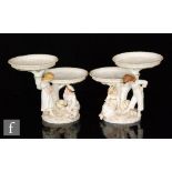 A pair of Royal Worcester figural two tiered comports modelled by James Hadley in the style of