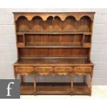 A reproduction oak dresser in the 18th Century style, the upright two-tier plate rack section with a