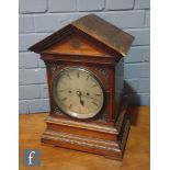 A late 19th Century oak cased bracket clock of architectural form, carved in the Aesthetic taste